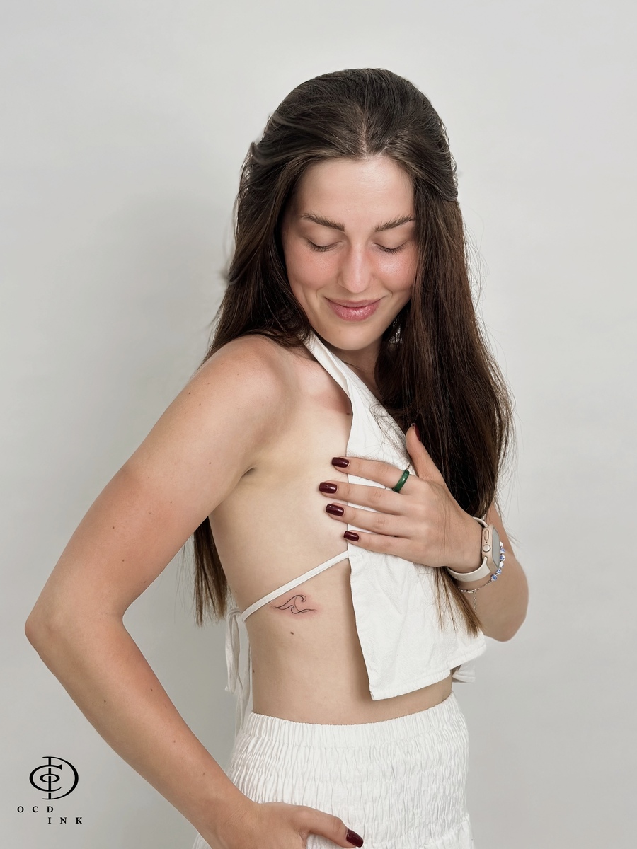 beautiful lady with wave tattoo on the rib - our client - OCD Ink Studio
