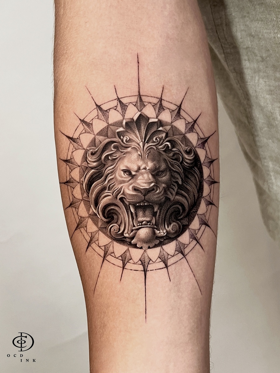 A black and grey realism stone lion statue tattoo on the forearm by OCD Ink Studio in Hanoi