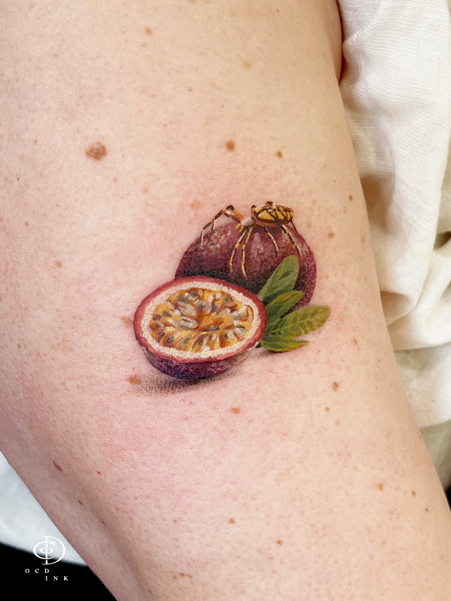 A color realistic tattoo of a passionfruit with a spider on top by OCD Ink Studio Hanoi