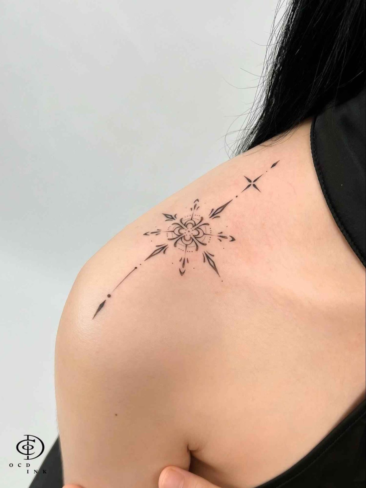 Blackwork Blackwork tattoo featuring a geometric floral star design with fine-line details on the shoulder
