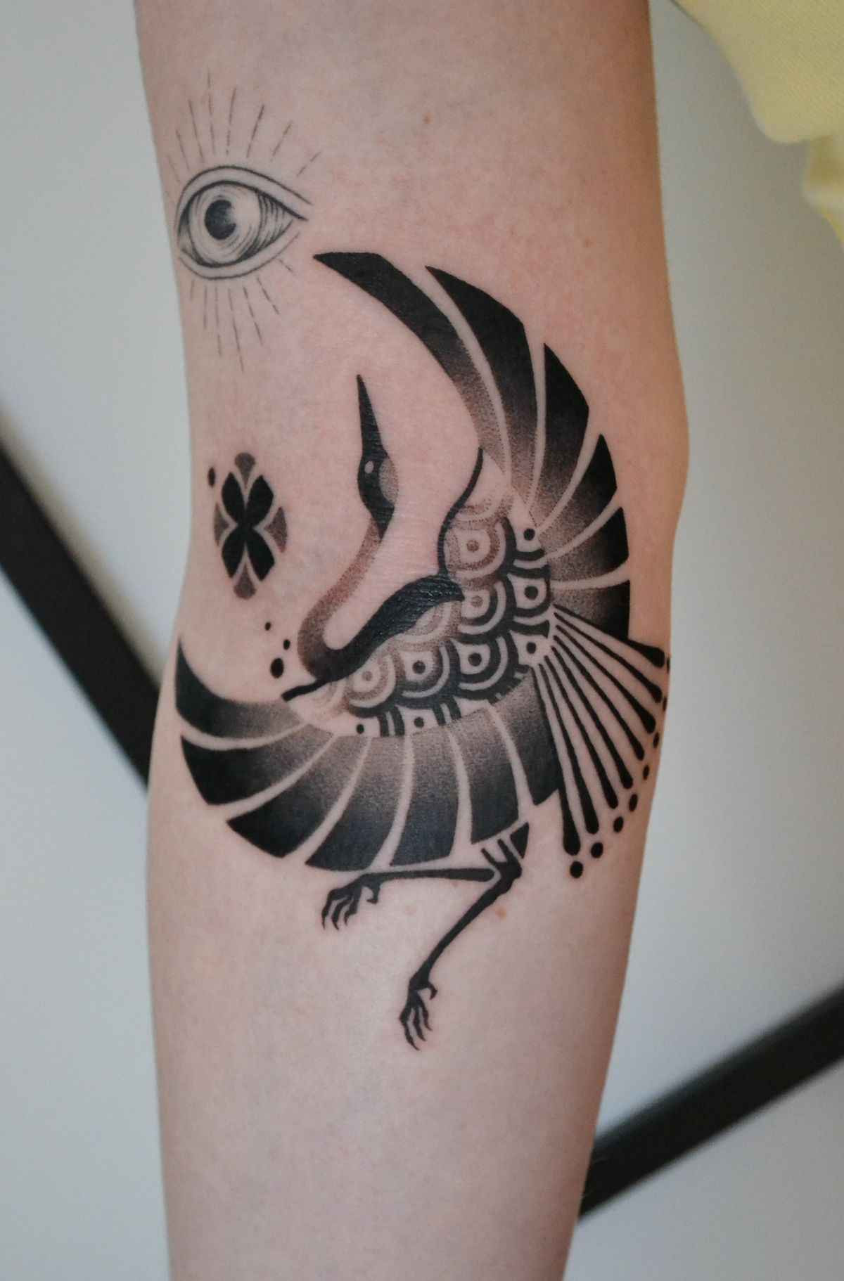 Bird tattoo featuring a stylized bird with geometric patterns and ornamental details