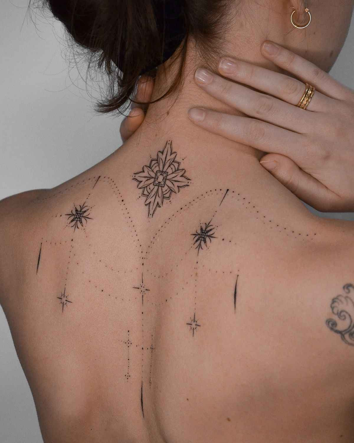Chandelier tattoo featuring ornamental geometric details, delicate dotwork, and symmetrical decorative elements across the upper back