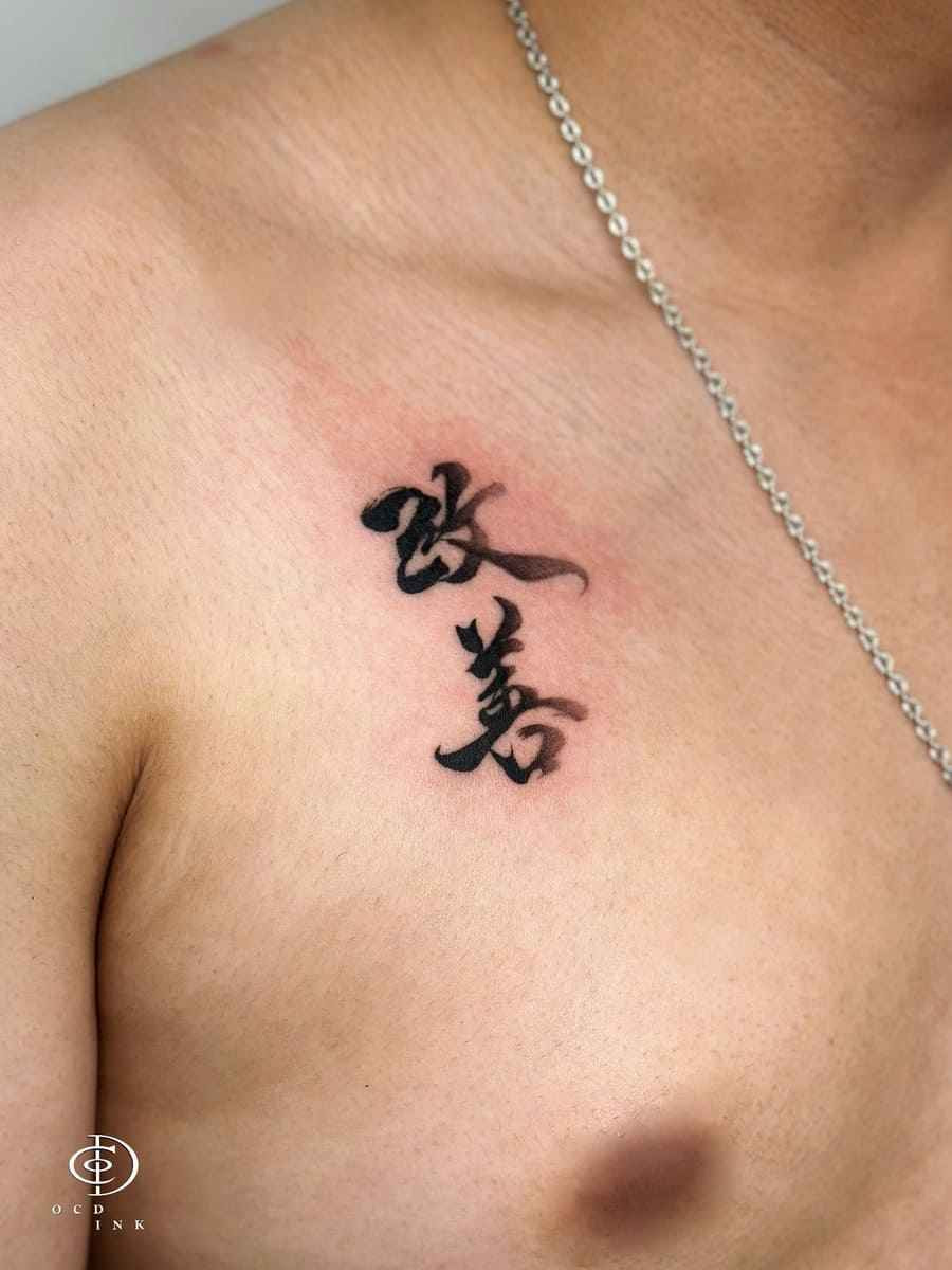 Hán Nôm character tattoo in bold black calligraphy on the upper chest