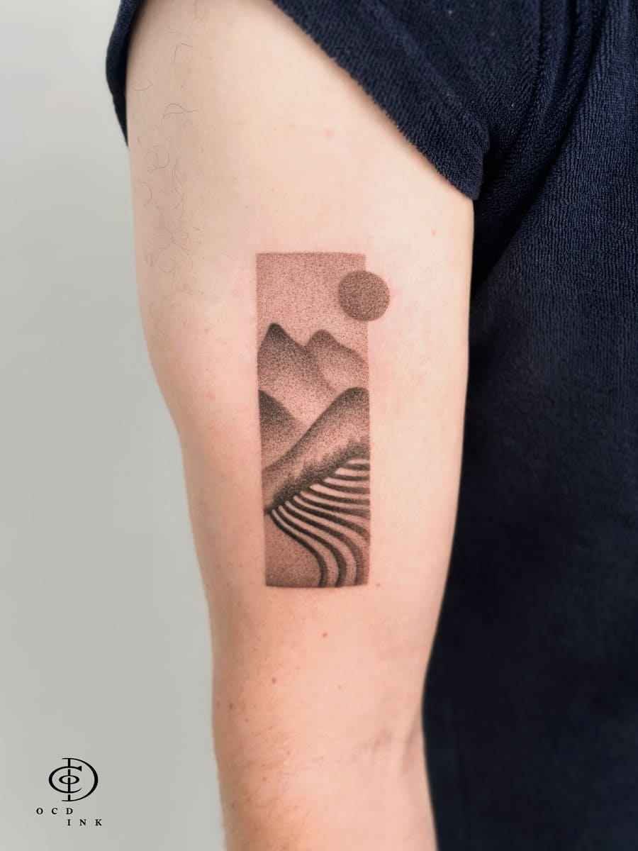 Vietnam-inspired dotwork tattoo of layered mountain ranges, terraced rice fields, and a textured sun, framed within a minimalist vertical rectangle using fine stipple shading.