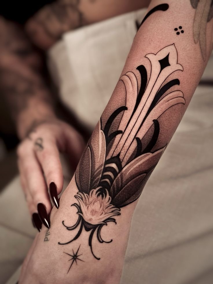 Hybrid dotwork tattoo featuring a stylized insect motif on the forearm, combining bold blackwork shapes, fine line detailing, and smooth stipple shading