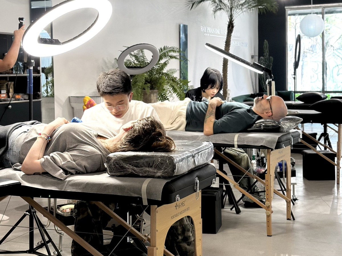 COLOR Professional tattoo artists working with clients in a modern tattoo studio featuring clean workstations, adjustable lighting, and a hygienic environment.