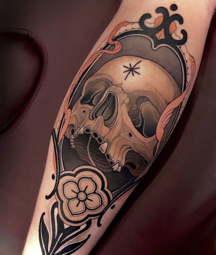 COLOR Neo traditional color tattoo featuring a detailed human skull framed by ornamental floral elements and bold black outlines, enhanced with muted earth-tone shading.