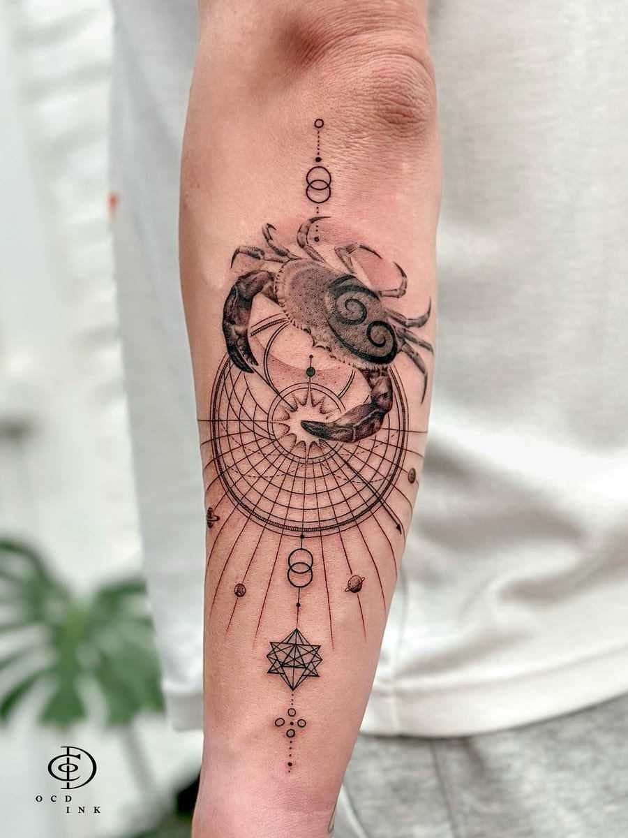 Fine-line graphic tattoo of a crab surrounded by orbital patterns, geometric shapes, planets, and symmetrical celestial details