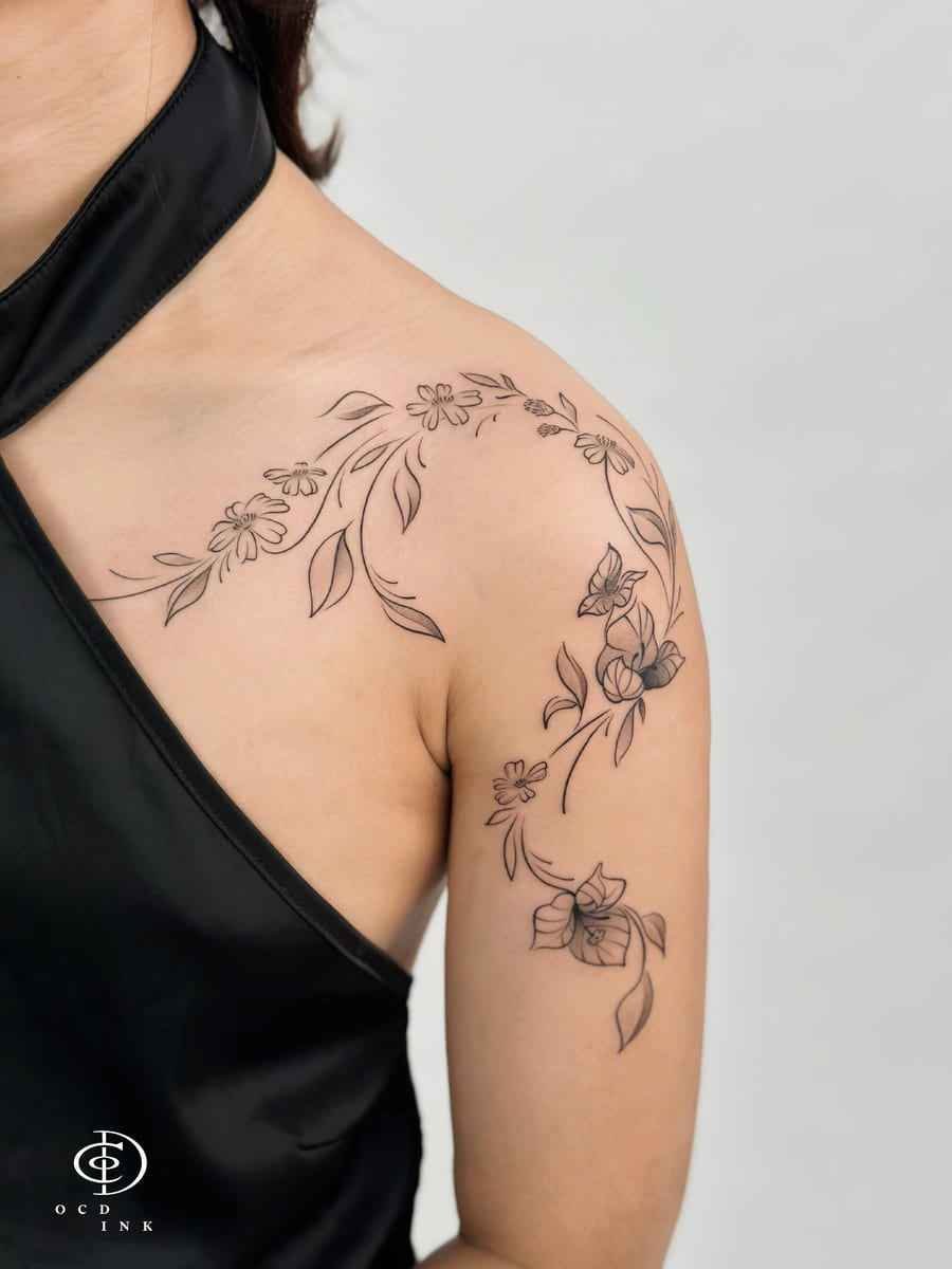 ILLUSTRATION Fine-line illustration tattoo of flowers and leafy vines flowing from the shoulder down the upper arm