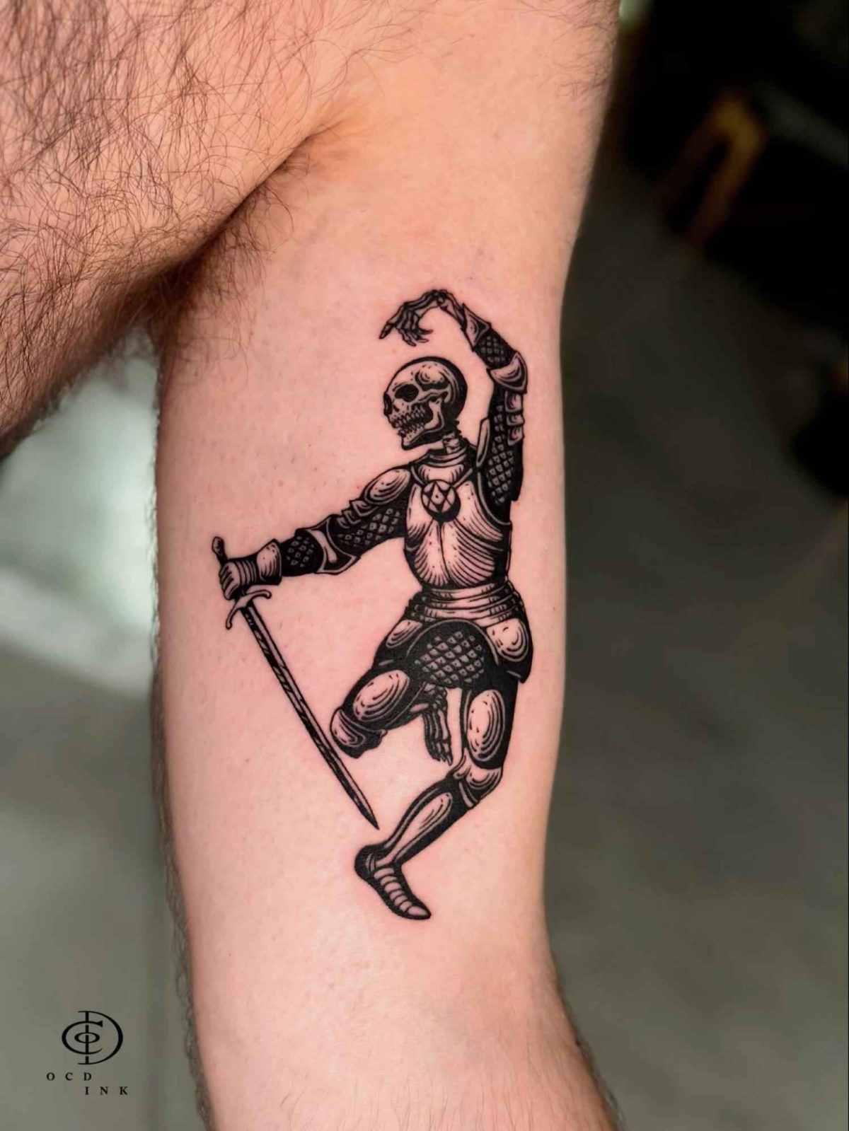 ILLUSTRATION Illustration tattoo of an armored skeleton knight holding a sword in a dynamic pose on the upper arm
