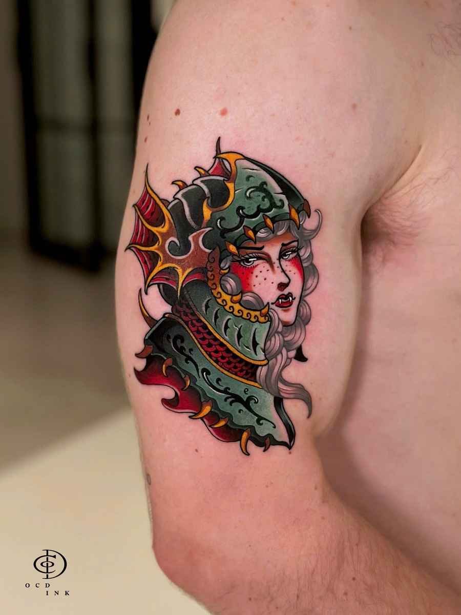 ILLUSTRATION Colorful illustration tattoo of a female warrior wearing ornate fantasy armor and a horned helmet on the upper arm
