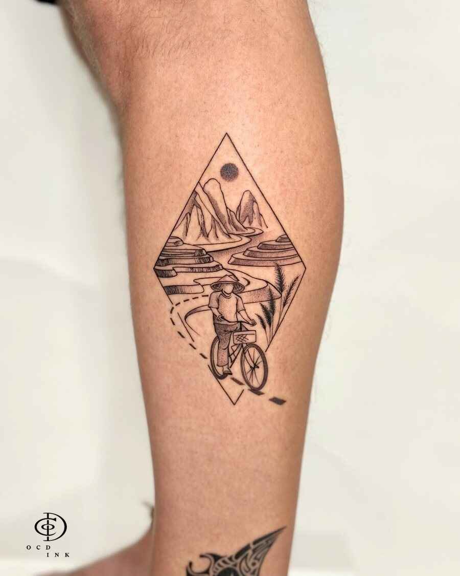 ILLUSTRATION Illustration tattoo of a cyclist in a conical hat riding through terraced fields and mountains