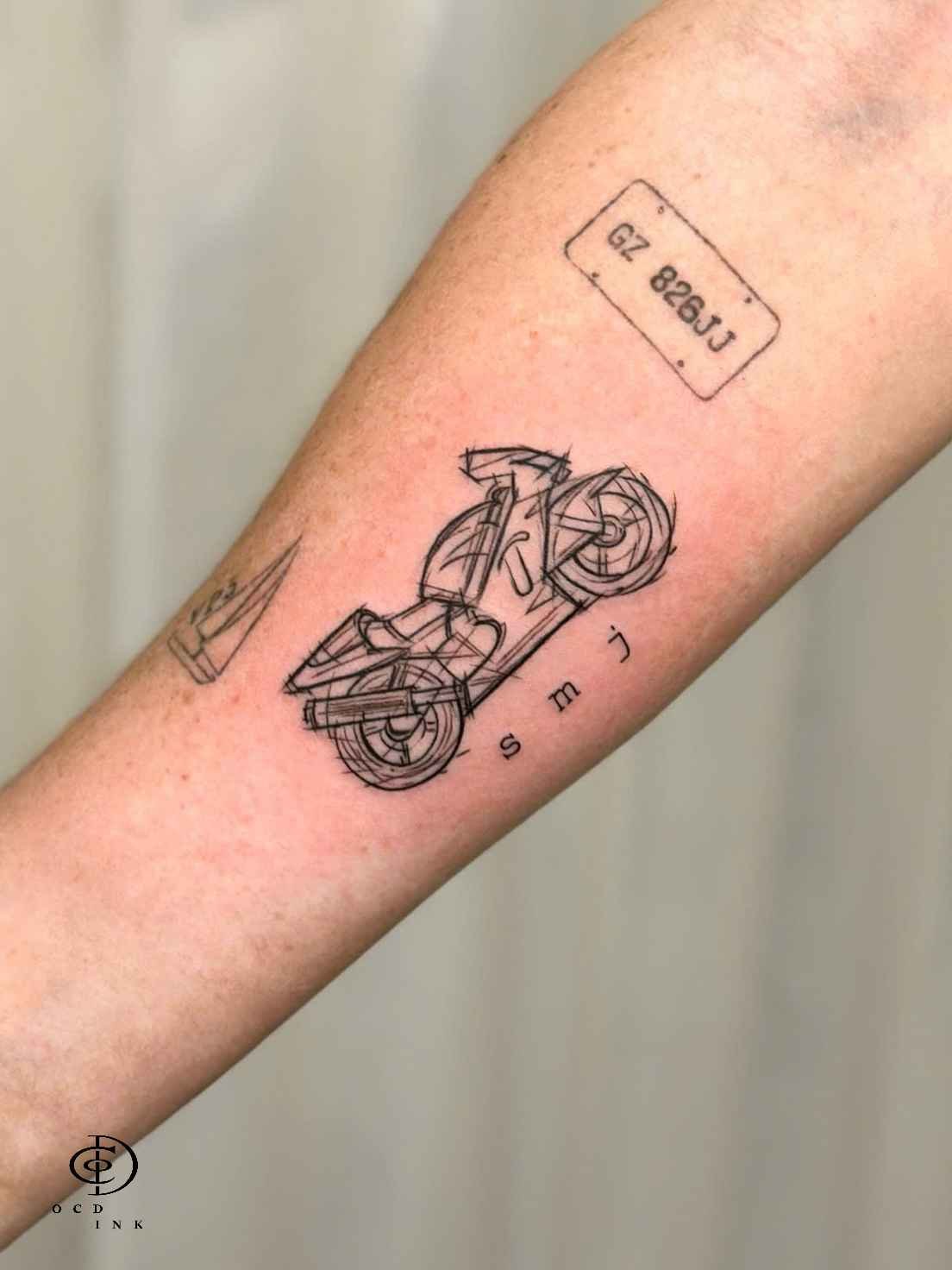 ILLUSTRATION Illustration tattoo of a motorcycle rendered with abstract geometric linework on the forearm